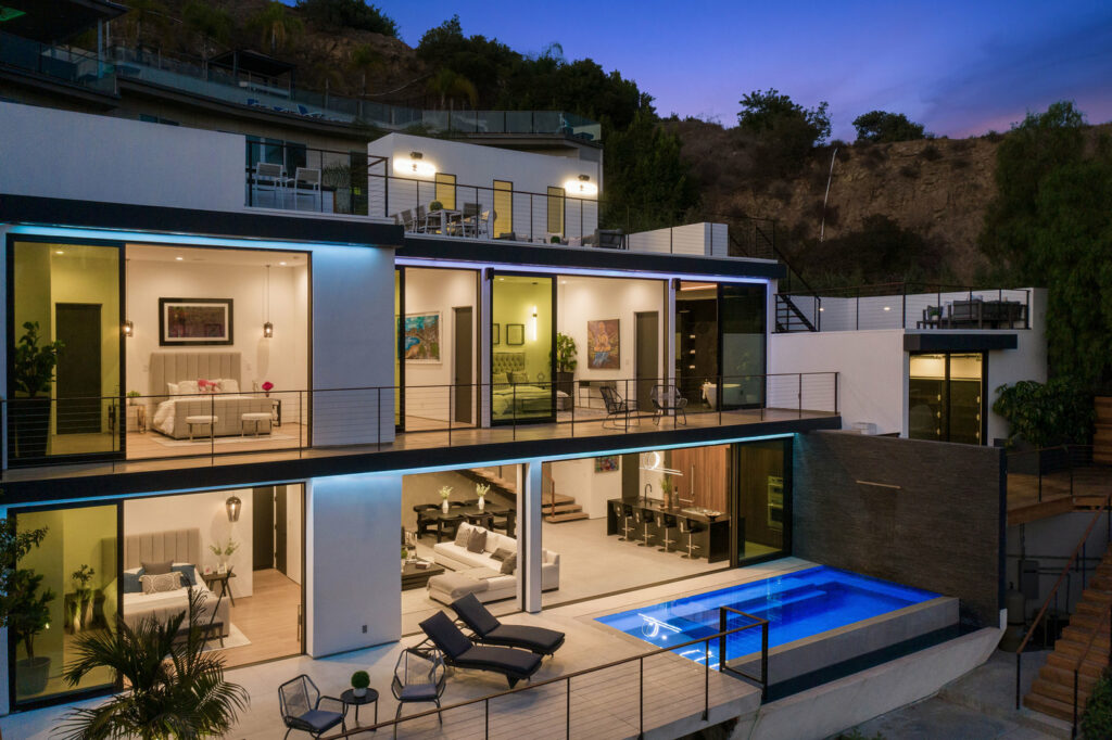 Luxurious multi-level home with pool at dusk