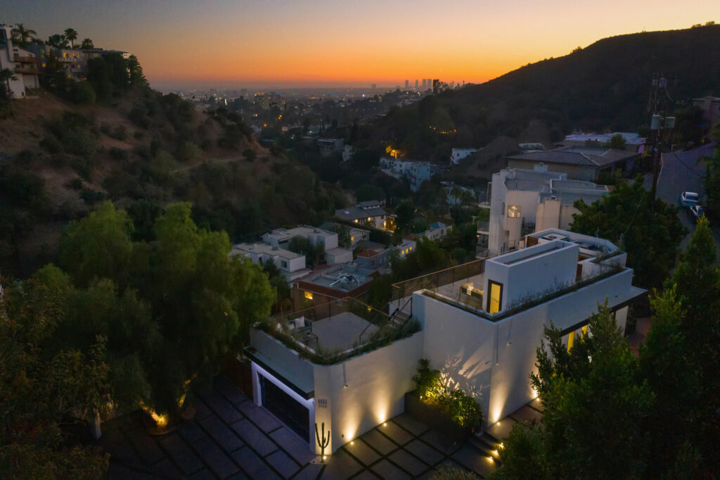 Sunset view over urban hills with modern house.