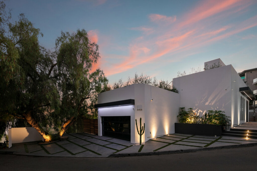 Modern house exterior at sunset with dramatic sky.
