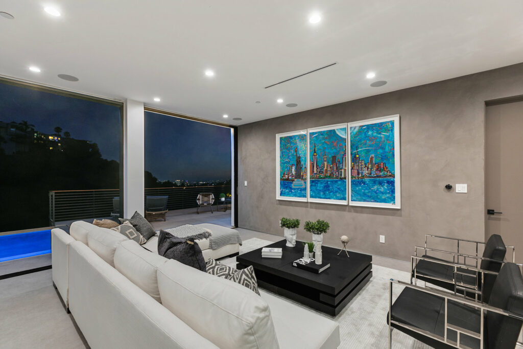 Modern living room with cityscape art and night view.