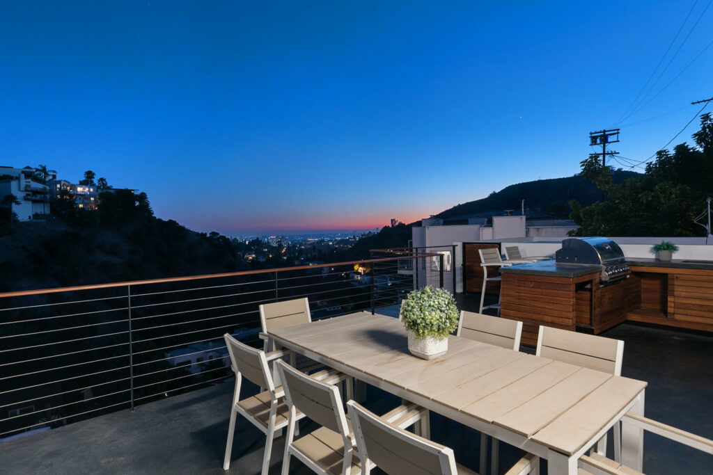 Rooftop patio dining overlooking sunset and city lights