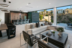 Modern open-plan kitchen and living room with hillside view.