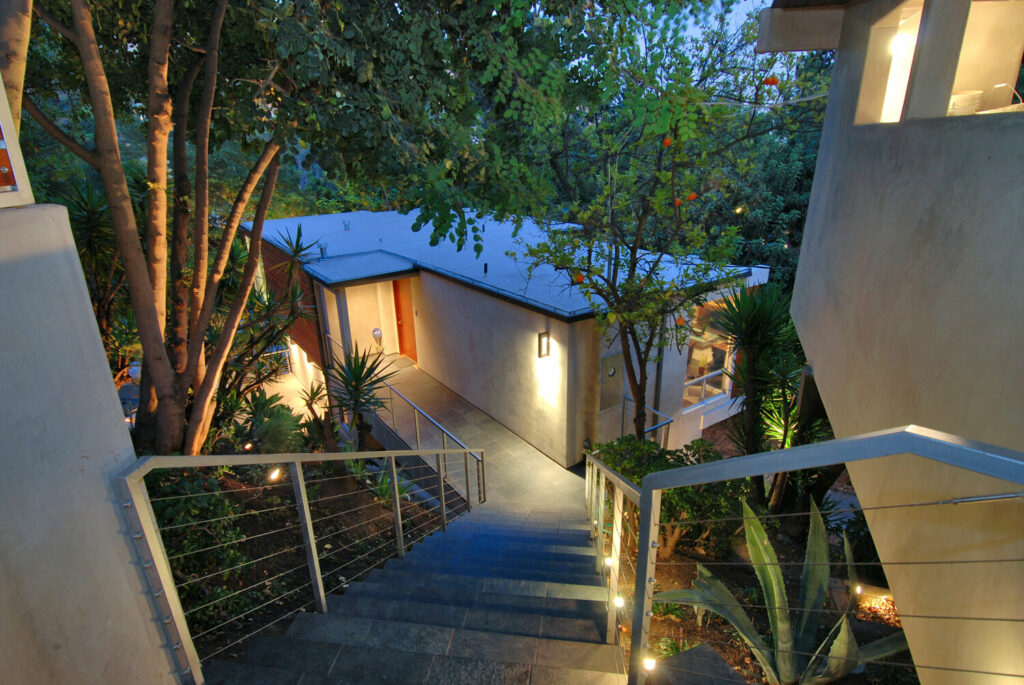 Modern house entrance with evening lighting and garden.