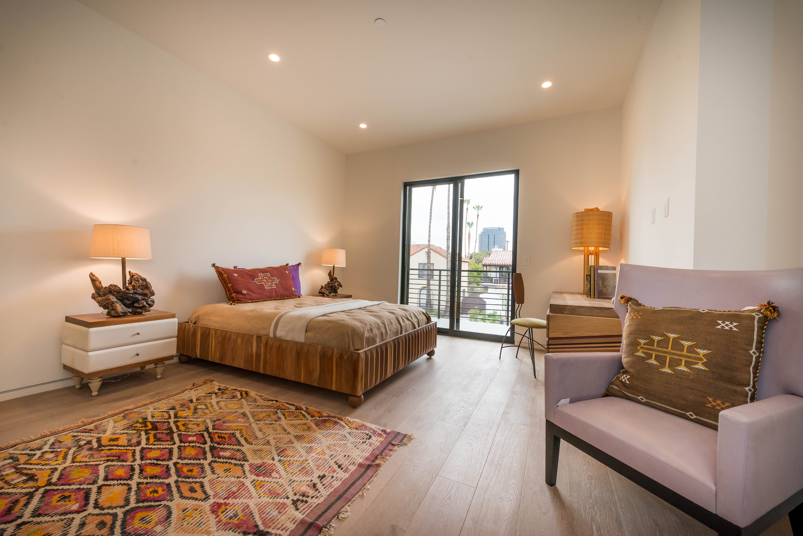 Modern bedroom with balcony and eclectic decor.