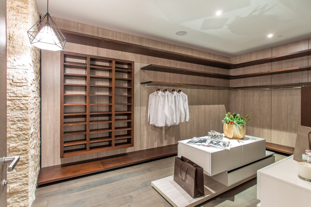 Modern boutique interior with wooden shelves and designer clothes.