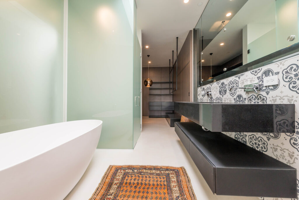 Modern bathroom interior with elegant bathtub and decorative tiles.