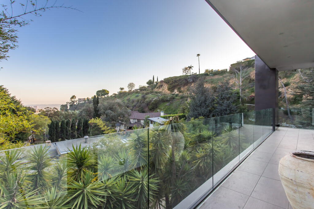 Hillside home terrace with panoramic view at dusk.