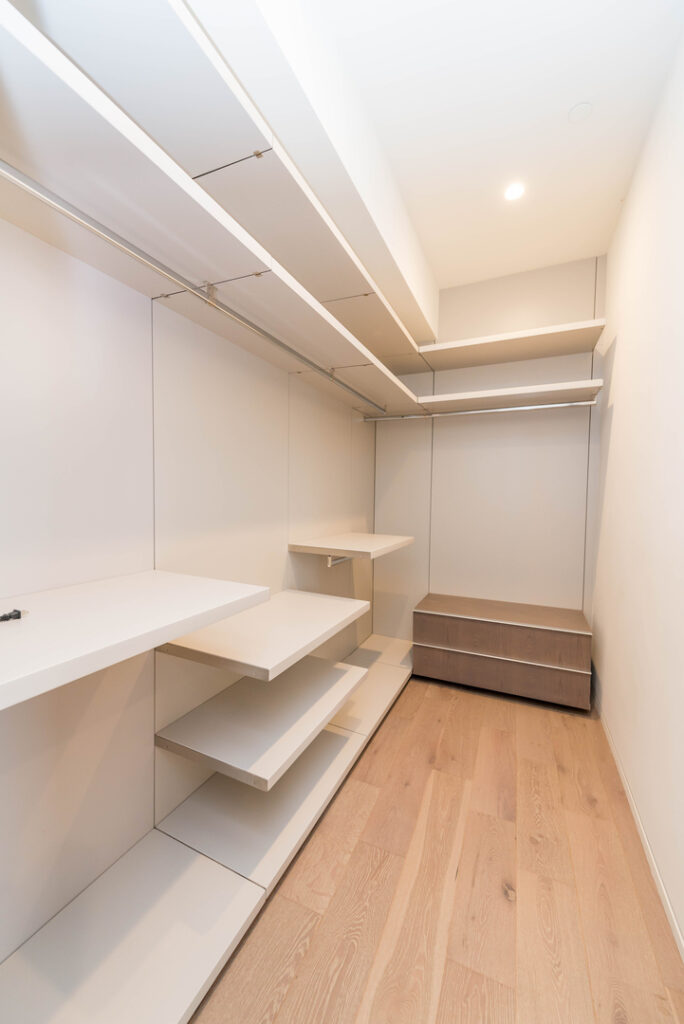 Modern walk-in closet interior design with shelves.