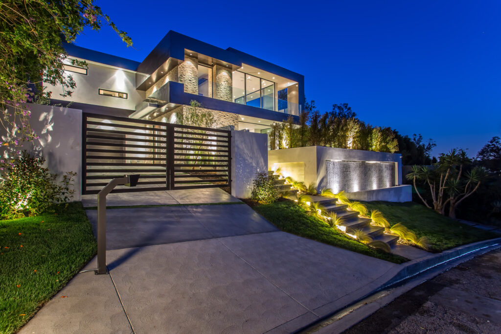 Modern house exterior at twilight with landscape lighting.