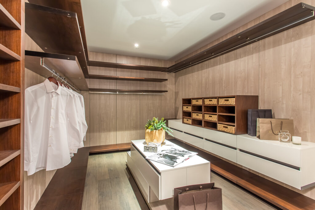 Elegant modern walk-in closet design with shelves and lighting.