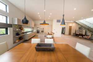 Modern spacious kitchen with wooden dining area and staircase.