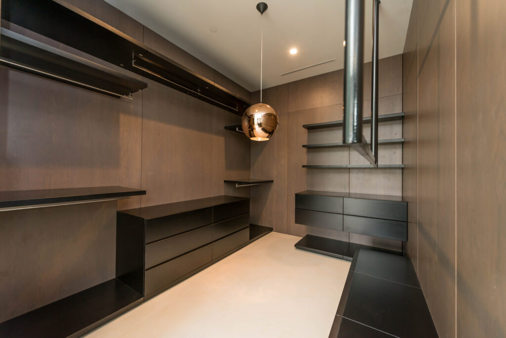 Modern walk-in closet interior with shelving and lighting.