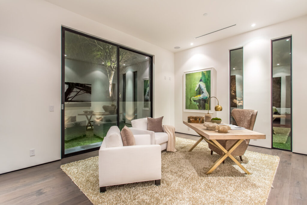 Modern living room interior with artwork and garden view.