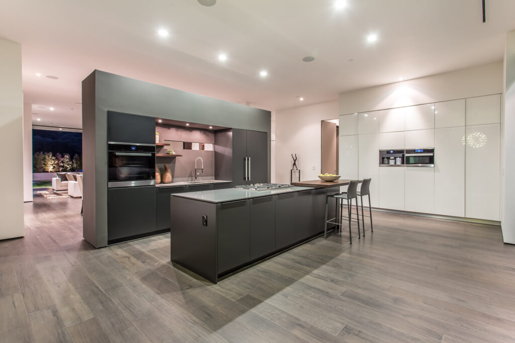 Modern kitchen interior with island and hardwood floors.