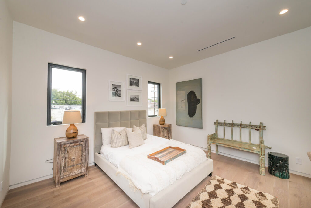 Modern bedroom with neutral decor and natural light.