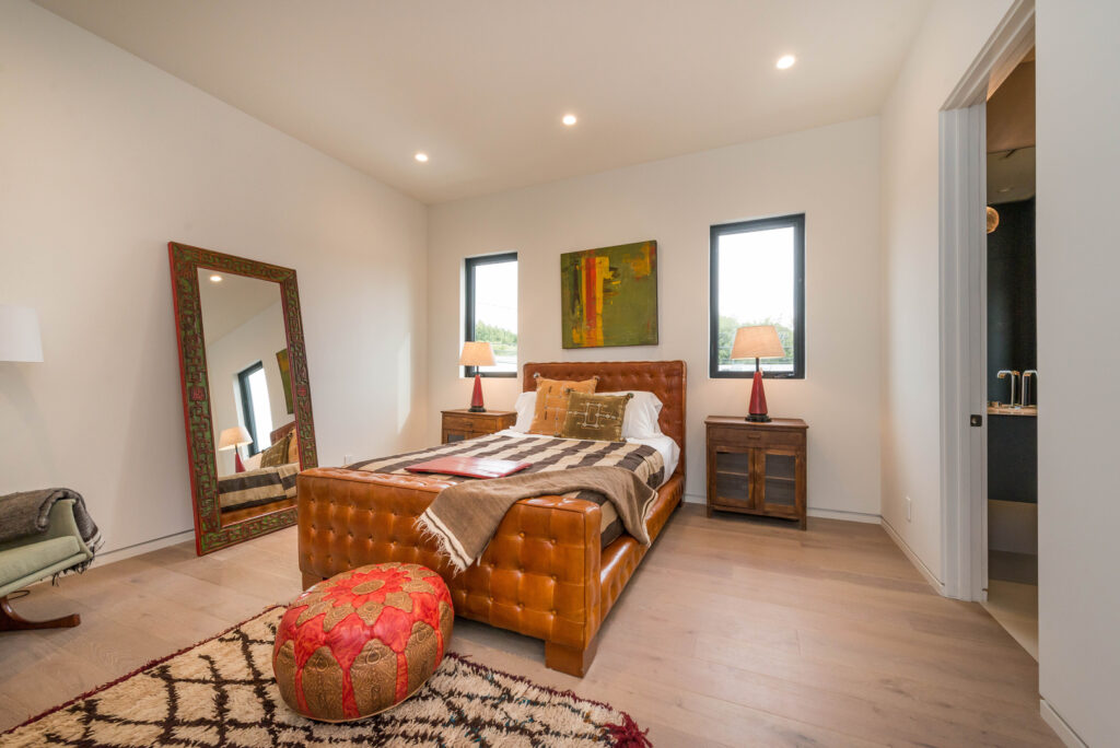 Cozy modern bedroom with wooden furniture and decorative rug.