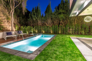 Luxurious backyard pool with lighting at night.