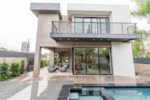 Modern home exterior with pool and balcony.