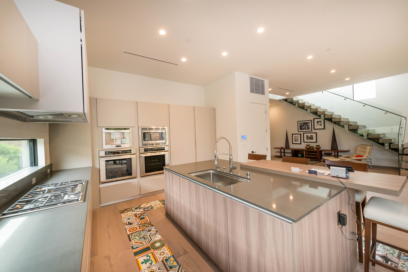 Modern kitchen interior with island and staircase.