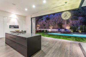 Modern kitchen interior with pool view at dusk.