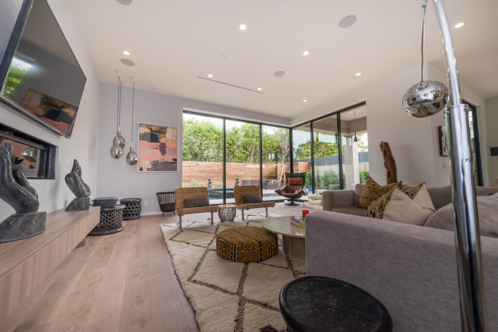 Modern living room interior with large windows and garden view.