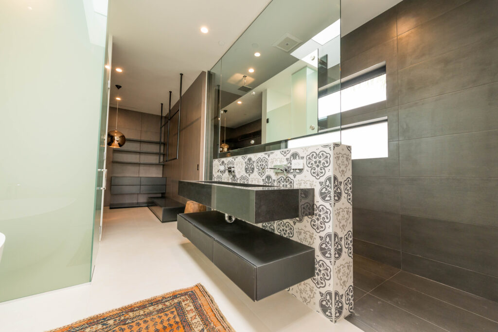 Modern bathroom interior with decorative tiles and lighting.