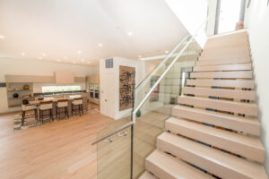 Modern kitchen with floating wooden staircase.