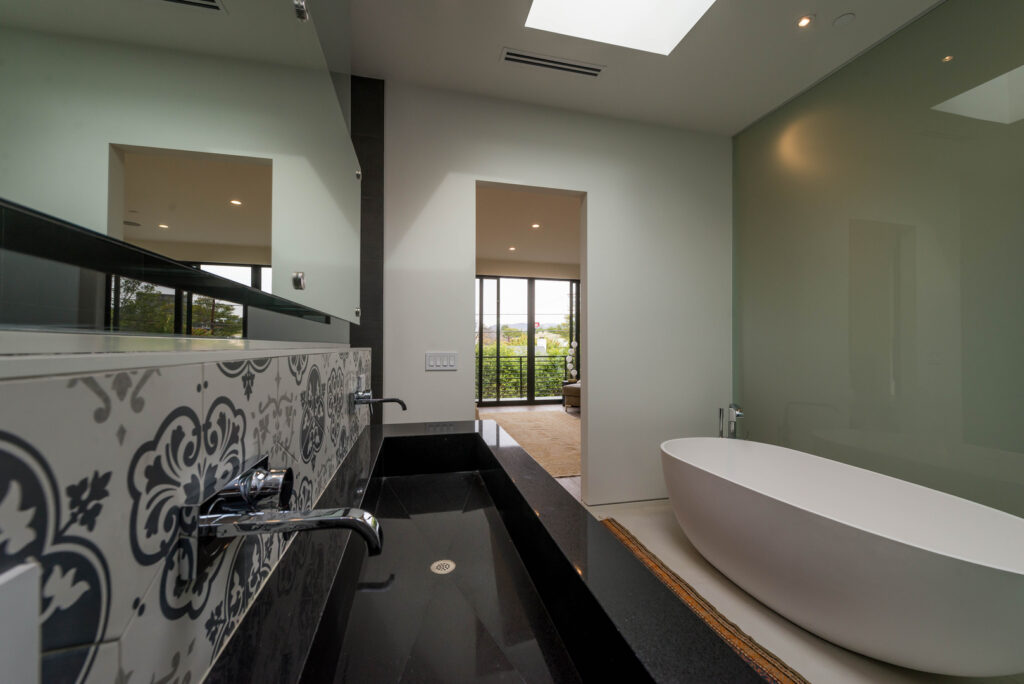 Modern bathroom with freestanding tub and patterned tiles.