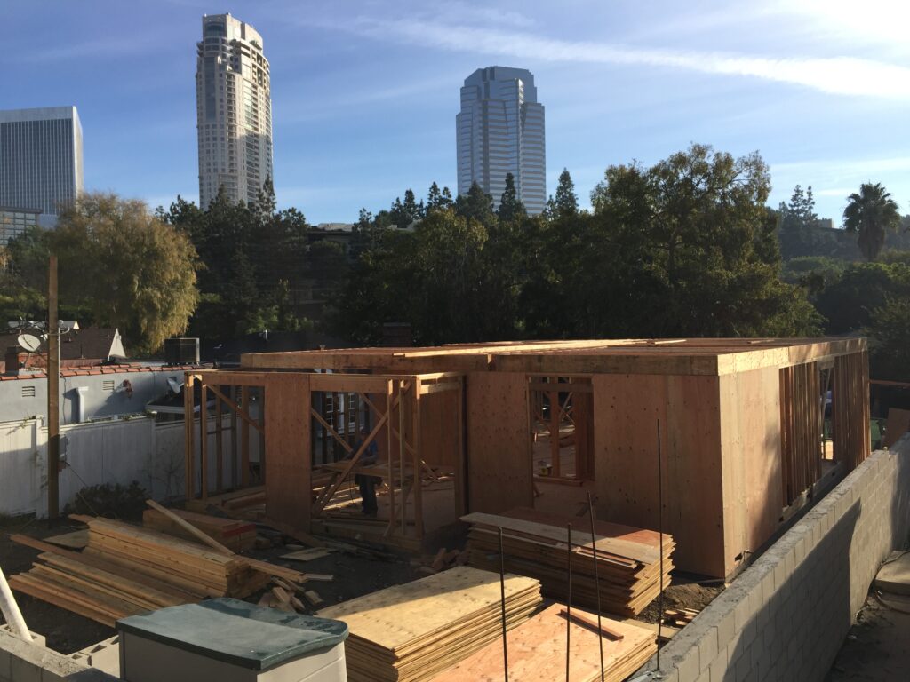 Construction site with unfinished building and city skyline.