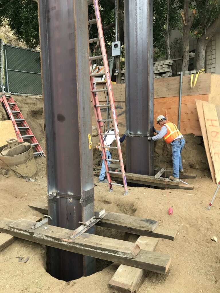 Construction worker aligning steel beams at site
