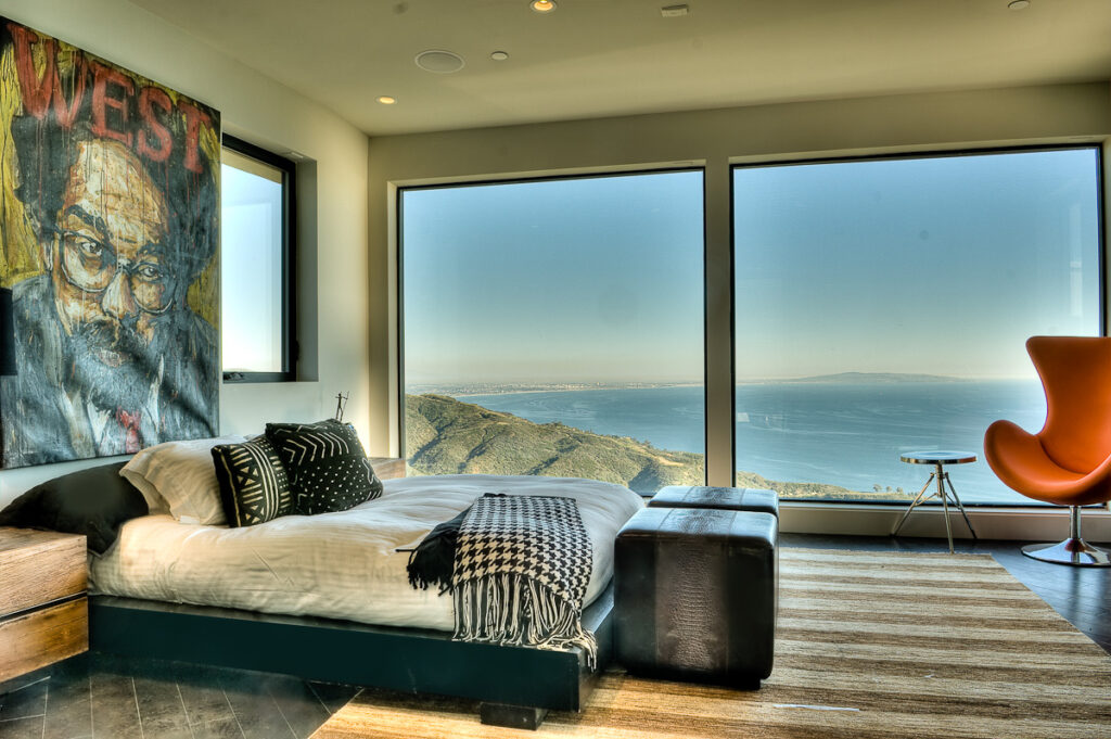 Modern bedroom with ocean view and art decor.