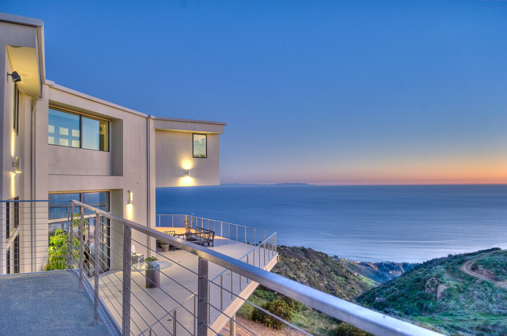 Coastal home balcony overlooking sunset and ocean