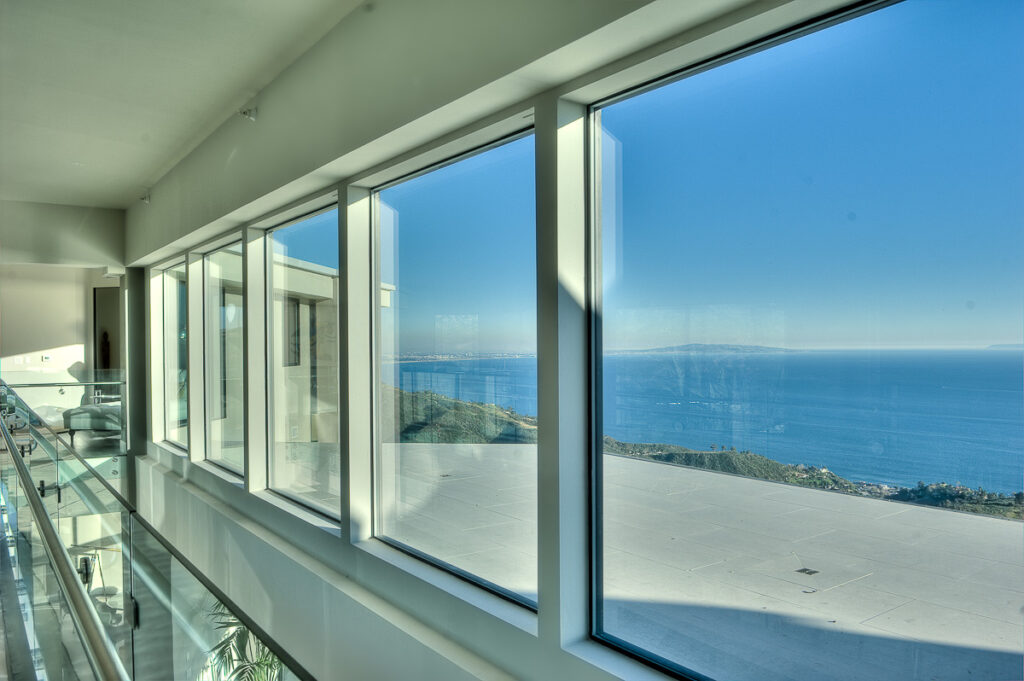 Modern home interior with ocean view through large windows.