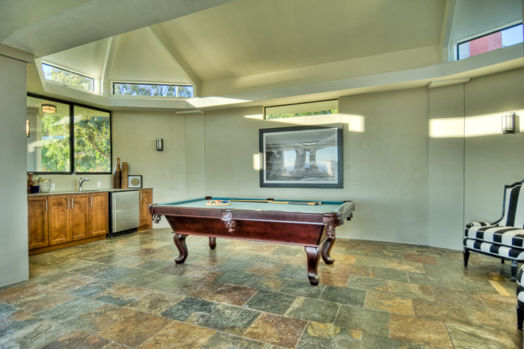 Spacious game room with billiard table and modern decor.