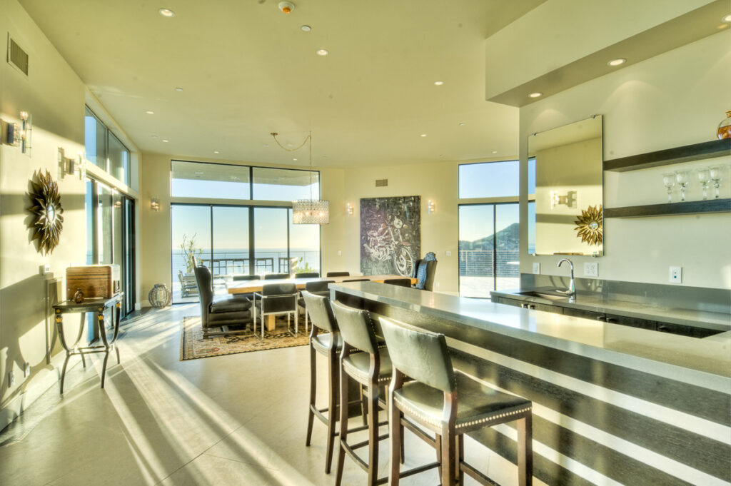Modern sunlit kitchen with ocean view.