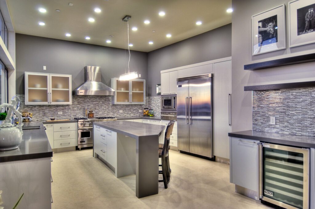 Modern kitchen interior with island and stainless appliances.
