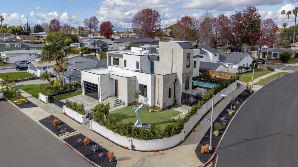 Modern suburban house with landscaped yard from aerial view.