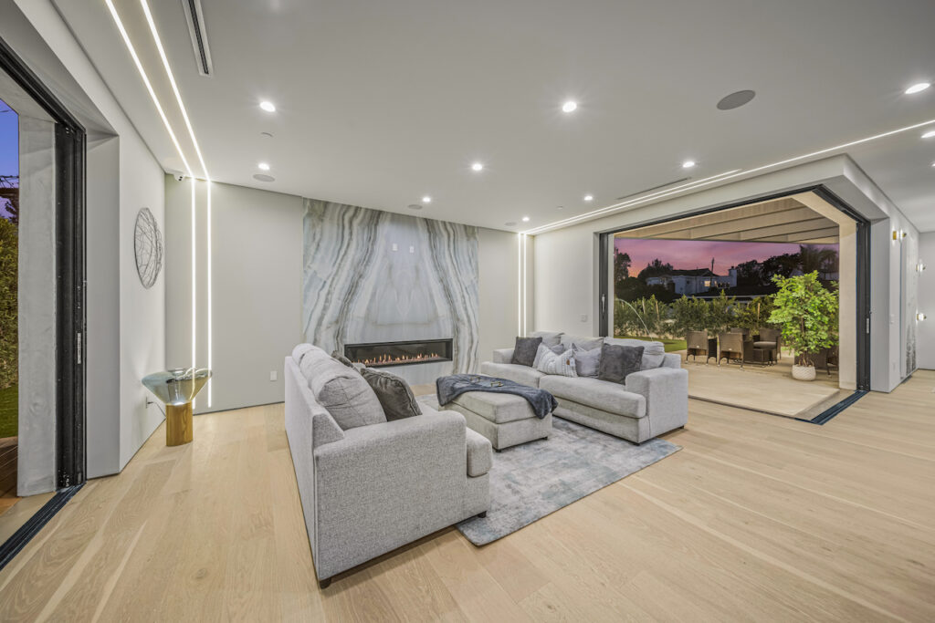 Modern living room with open patio doors at dusk.
