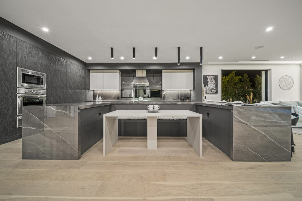 Modern kitchen with marble island and integrated appliances.