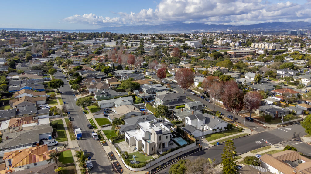 Aerial view of suburban neighborhood with mountains background.