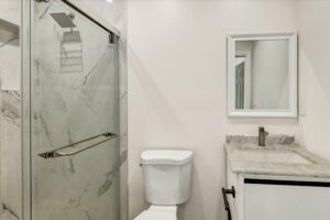 Modern bathroom with marble shower and white fixtures