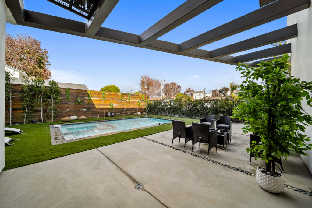 Backyard with pool, patio dining set, and modern pergola.