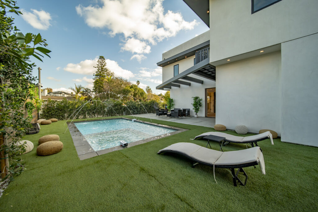 Modern backyard with pool and lounge chairs.
