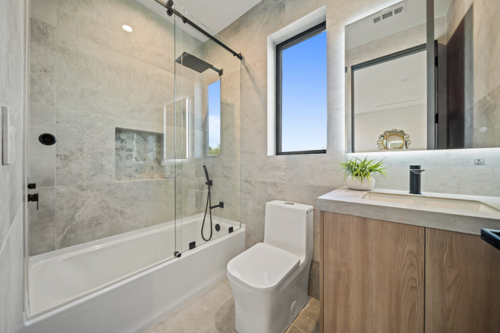 Modern bathroom with shower and natural light.