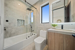 Modern bathroom with shower and natural light.