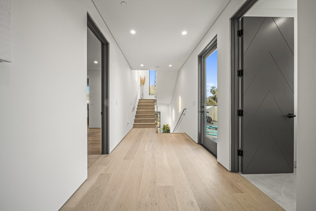 Modern hallway interior with wooden floors and natural light.