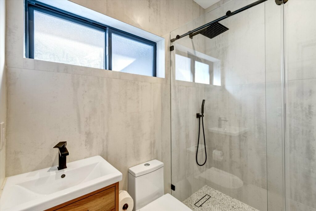 Modern bathroom with walk-in shower and natural light.