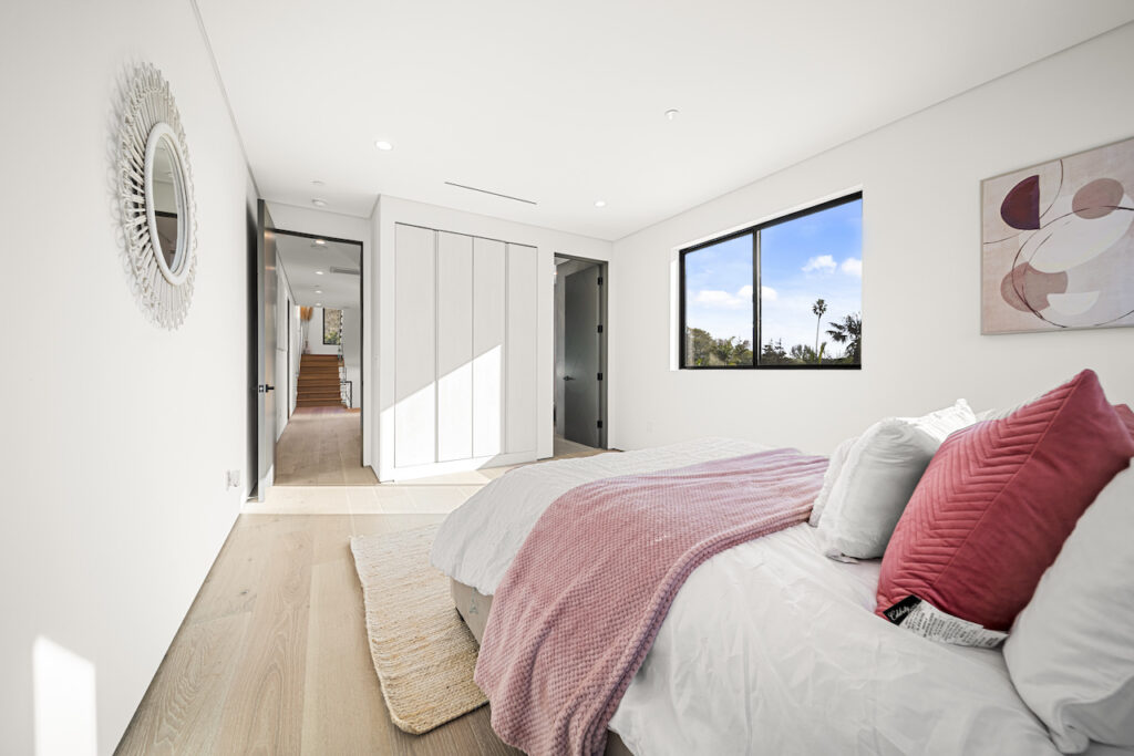 Bright modern bedroom with large window and artwork.
