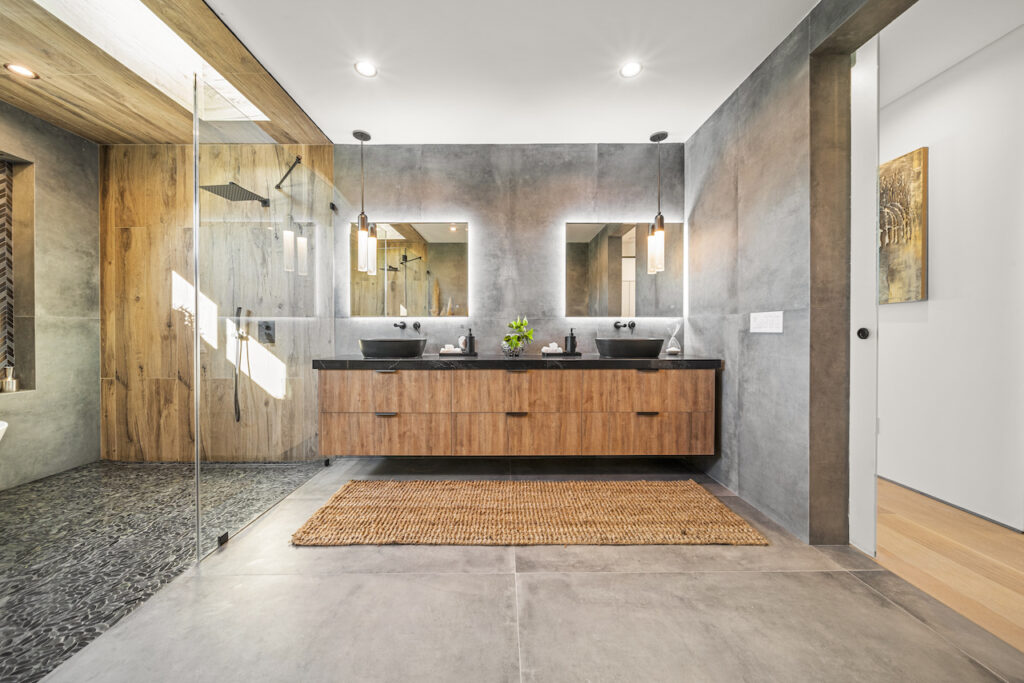 Modern bathroom interior with wood accents and concrete texture.
