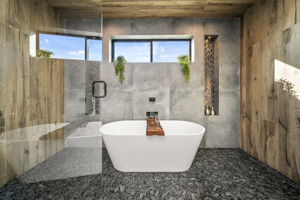 Modern bathroom with freestanding tub and concrete walls.